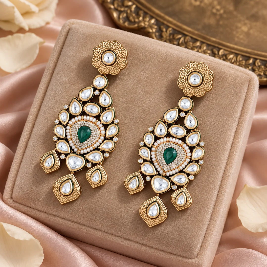 Pair of Padmika green statement earrings on a champagne velvet display with blush silk, ivory petals and a brass tray.