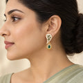 Side-profile Indian model in a sage saree wearing a Pallavi ivory and green paisley earring with a gold-tone teardrop pendant.