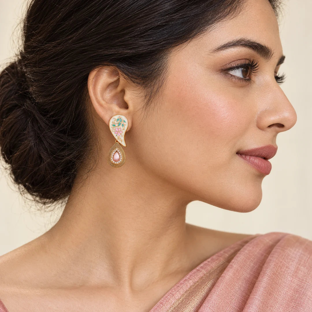 Side-profile Indian model in a blush saree wearing a Pallavi ivory paisley earring with pastel floral details and a pink drop.