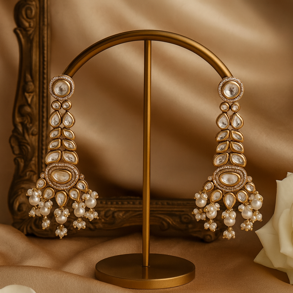 Pair of ornate earrings on a gold stand with a soft brown background