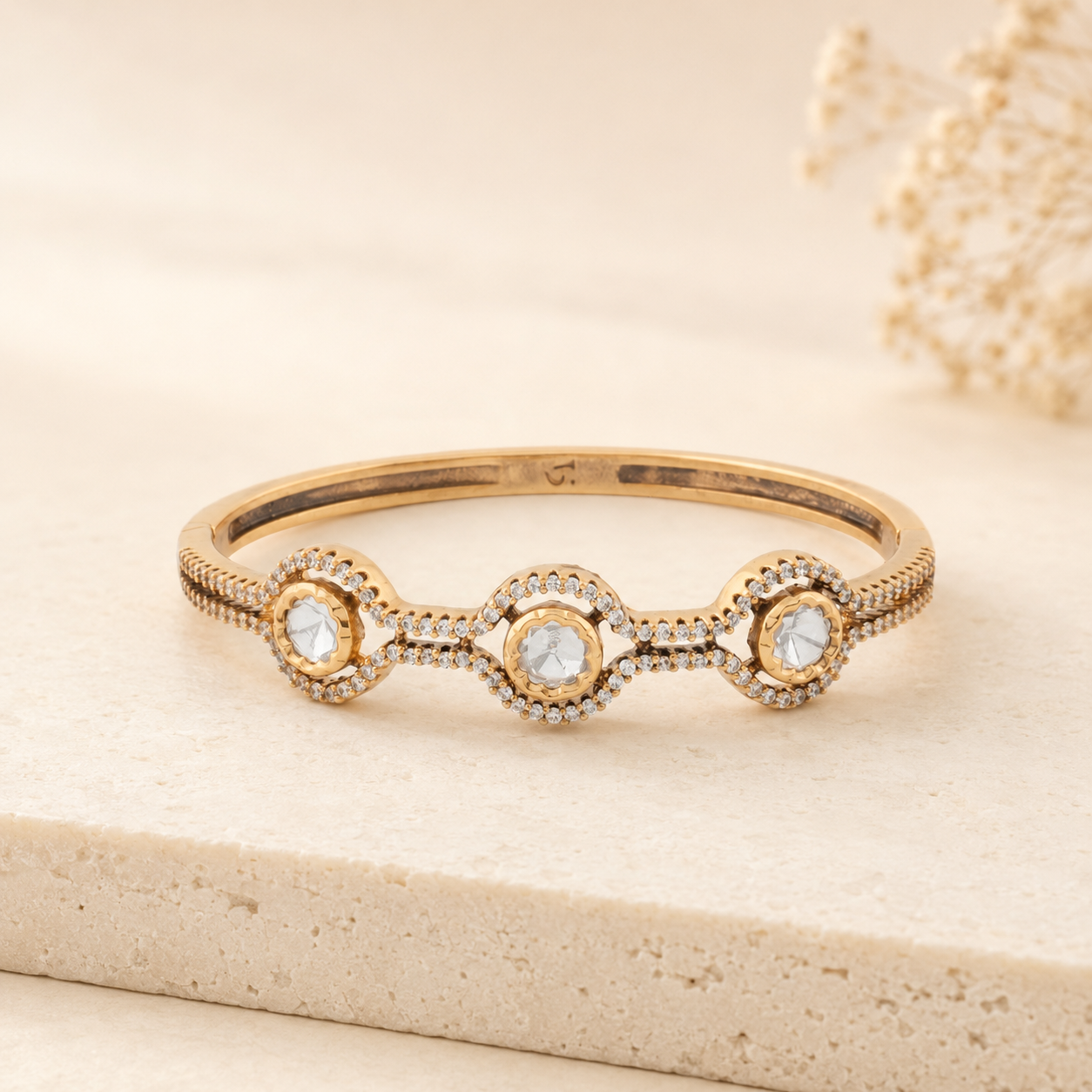 Ritvi gold Polki wave bracelet displayed in a warm ivory luxury setting