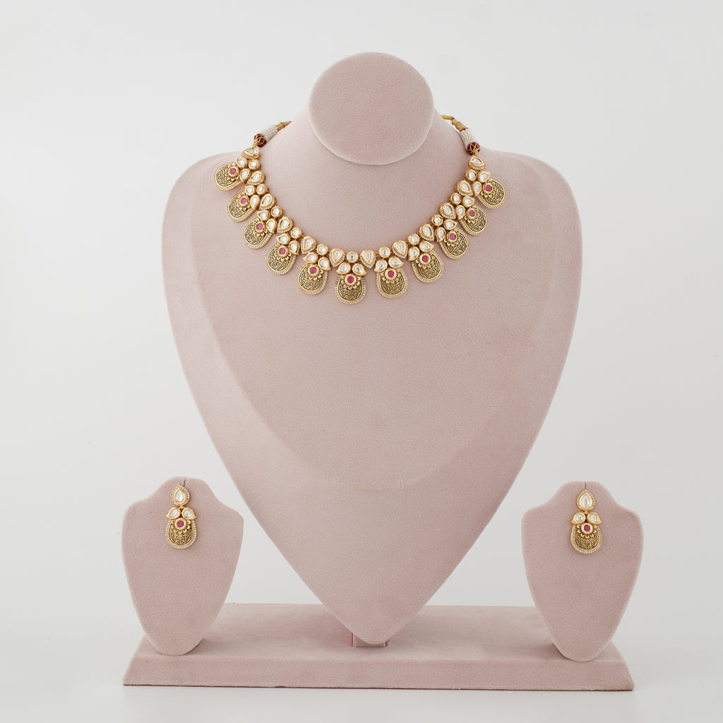 Rivanya antique gold artificial necklace set with diamond-look stones and ruby-red accents