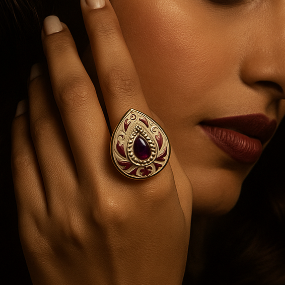 Woman wearing a gold ring with a purple gemstone against a dark background
