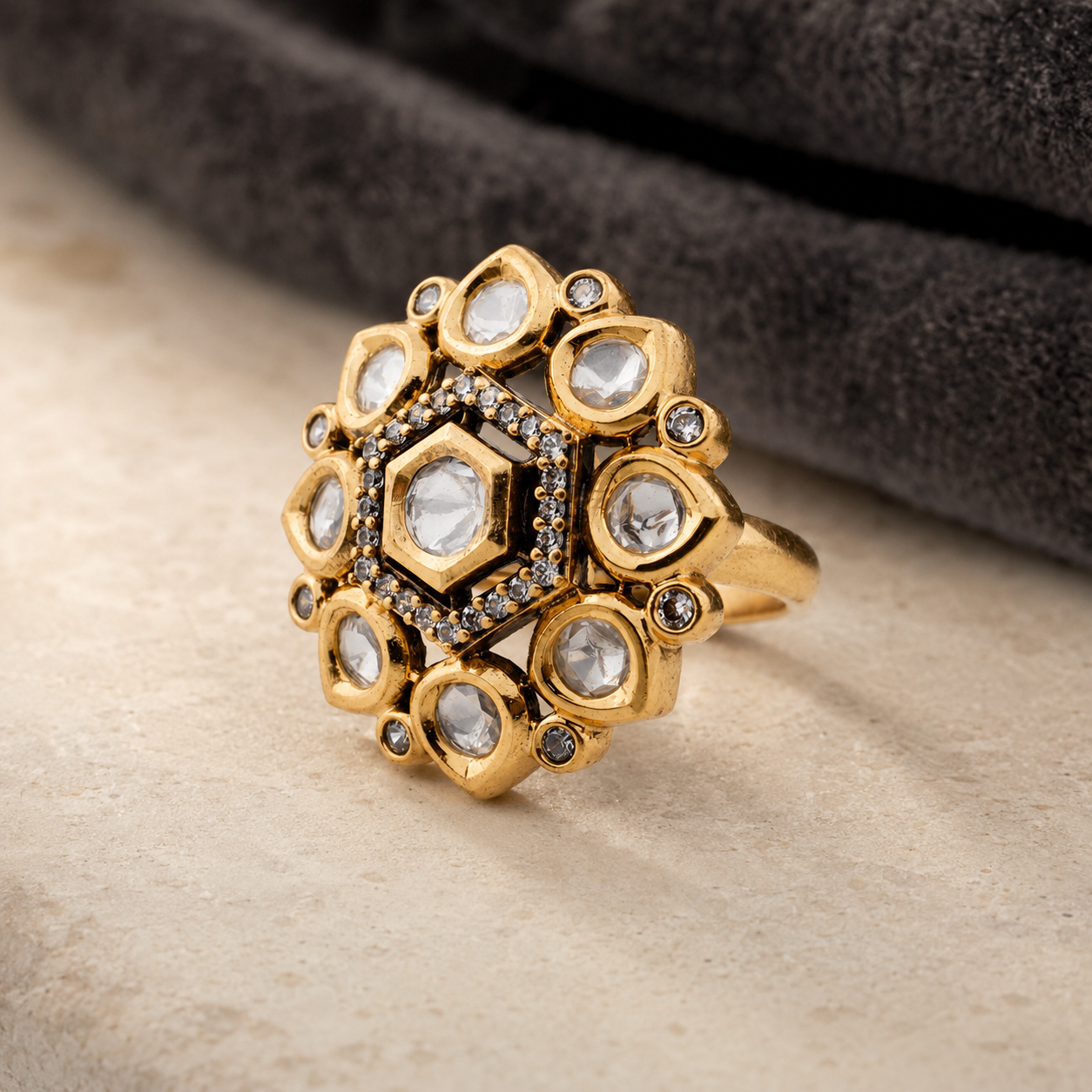 Gold-finish Kundan-look medallion ring displayed on a luxury neutral background