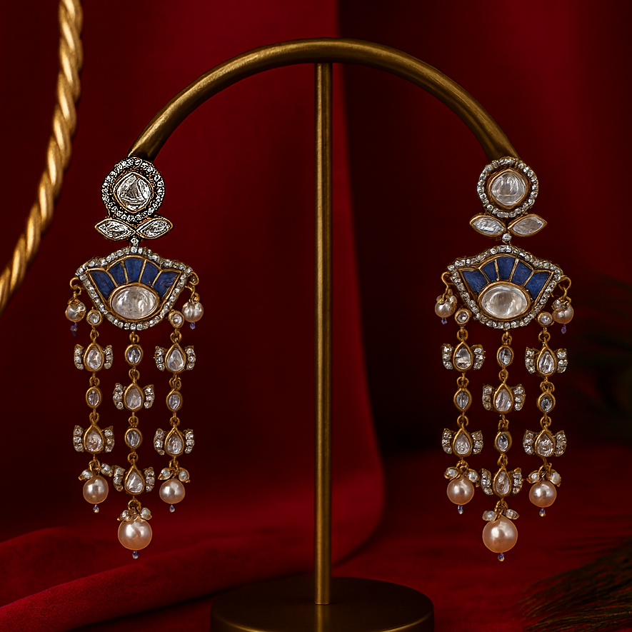 Ornate earrings on a gold stand against a red background